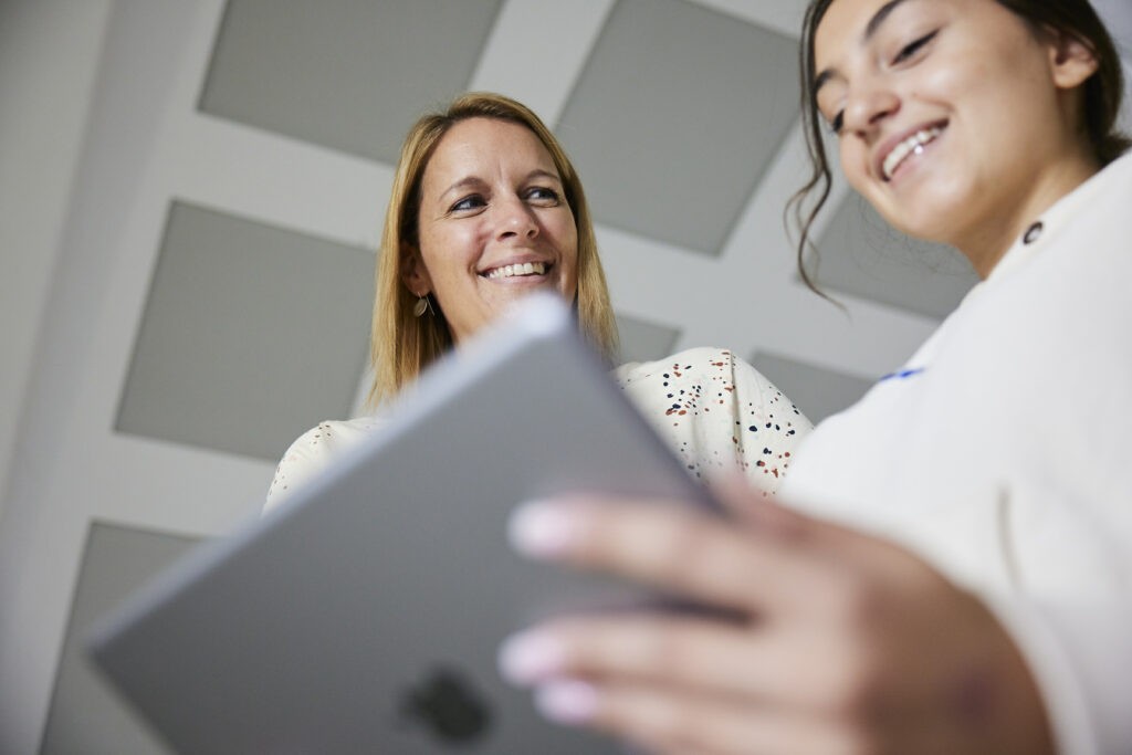 Lehrerin und Schülerin arbeiten zusammen am Tablet